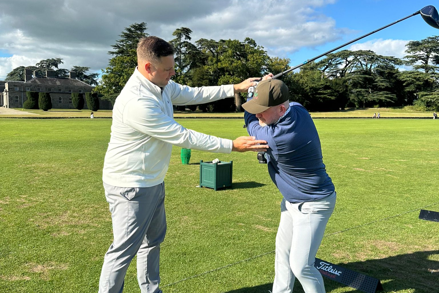 Photo of a golfer getting coaching on a golf course on a cloudy day